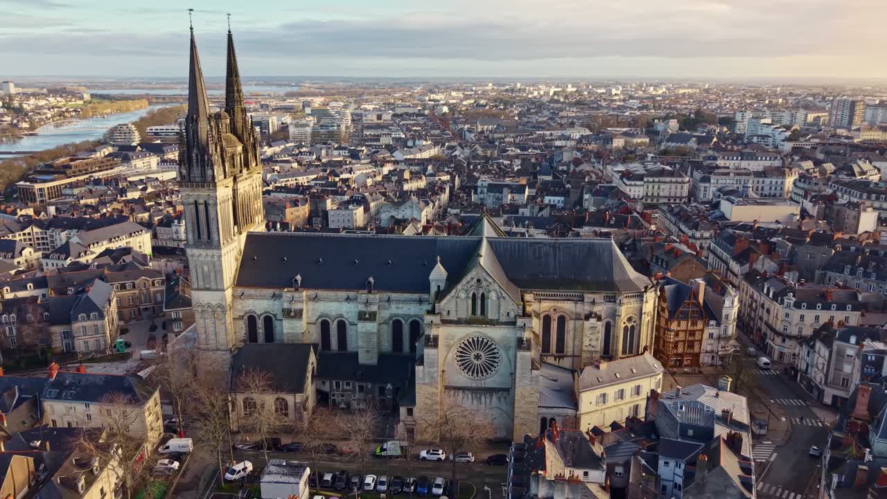 Orbita del drone attorno alla Cattedrale di Saint-Maurice all'alba, rivelando lo skyline della città di Angers e il fiume Maine nella Valle della Loira, Francia occidentale.
