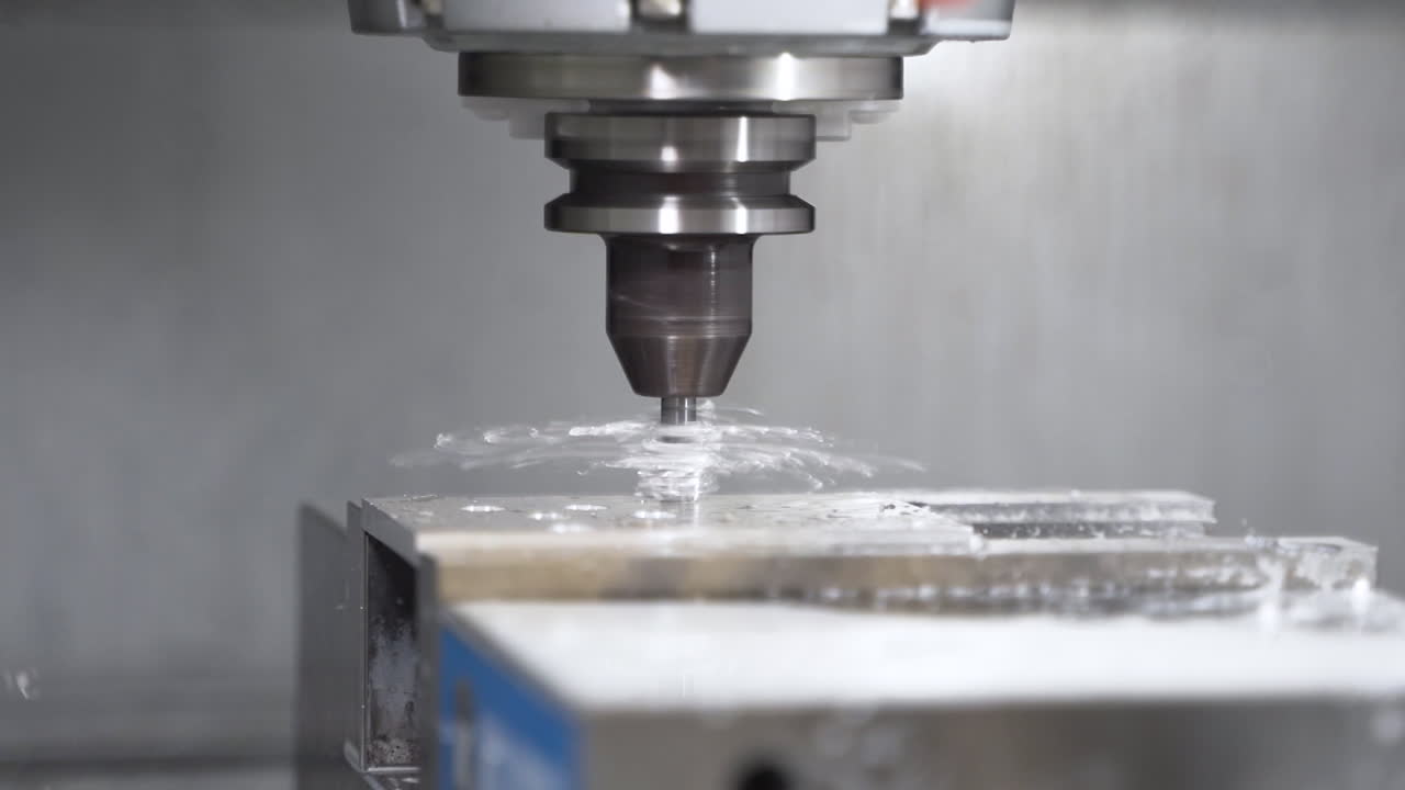 máquina cnc automática perforando agujeros en un bloque de acero, creando escombros