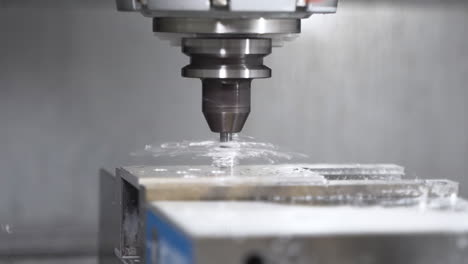 Máquina-Cnc-Automática-Perforando-Agujeros-En-Un-Bloque-De-Acero,-Creando-Escombros