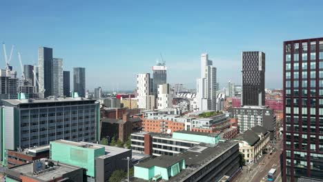 aerial drone flight over the rooftops revealing oxford road and the mancunian way in manchester city centre with a skyline view of deansgate towers