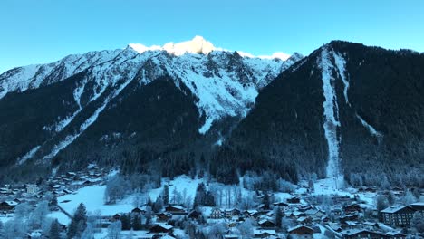 ski resort of chamonix, france with the alps mountains towering above the town on a cold snowy winter day