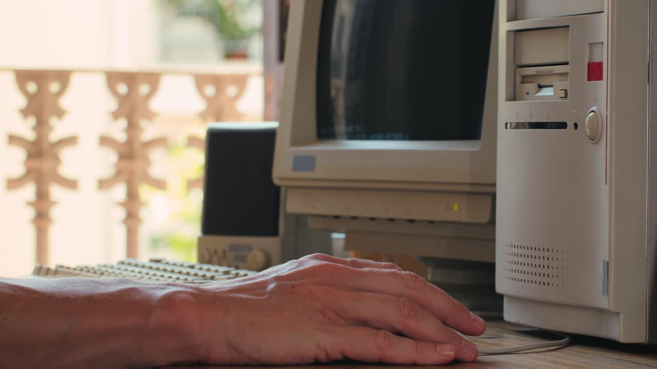 Man working and gaming on retro computer PC, IT engineer with vintage computer at home, using old fashion technology, close up of retro setup.