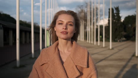 blonde woman looking at the camera outdoors.