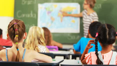 school kids raising hand in classroom