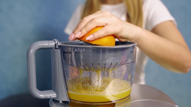 Woman making orange juice. Close up of woman making juice with fresh orange