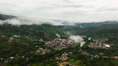 drone disparado con vistas a la aldea de san rafael en medio de las nubes de colombia