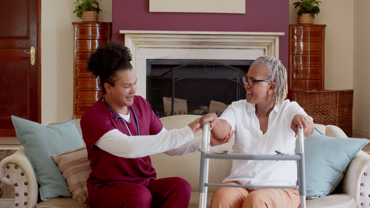 Caregiver assisting senior woman with walker at home, ensuring safety and support