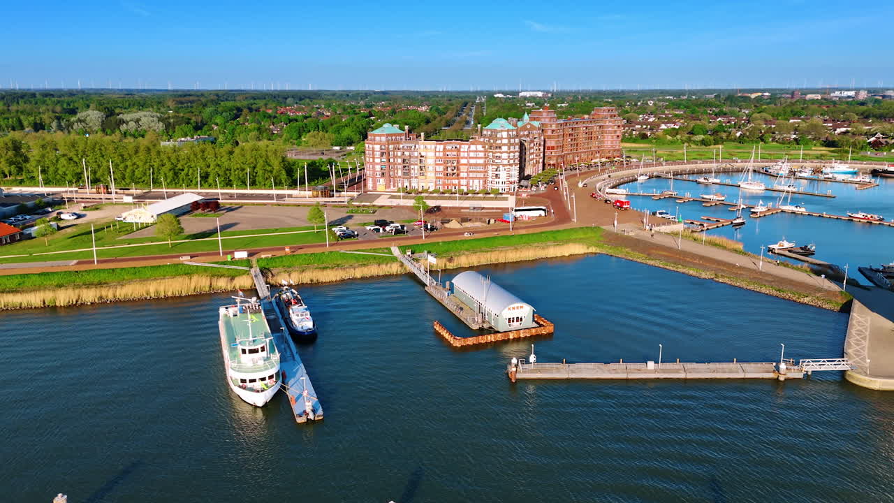 Sunny shore of Lelystad, the Netherlands. Flight along the picturesque waterfront approaching a port with boats.