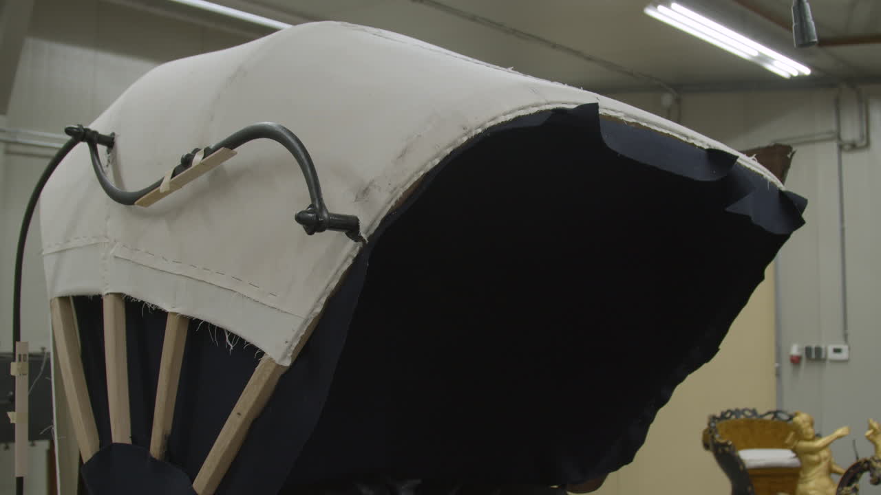 작업장에서 개조 중인 오래된 마차의 후드를 위로 기울이십시오.