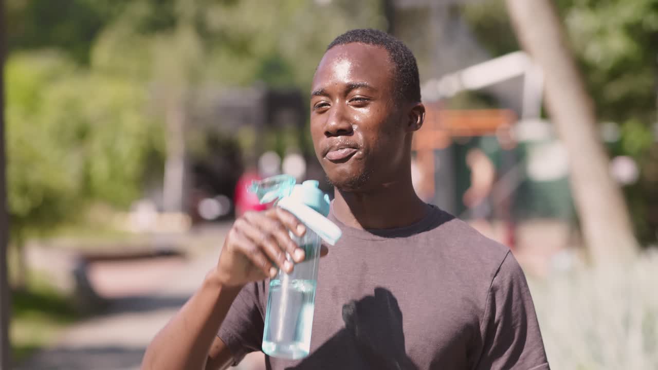 hombre bebiendo agua en un parque