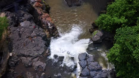 Vista-De-Arriba-Hacia-Abajo-Del-Agua-Que-Se-Hunde-En-La-Piscina-Natural-En-La-Cascada-De-Tegenungan-En-Bali,-Indonesia