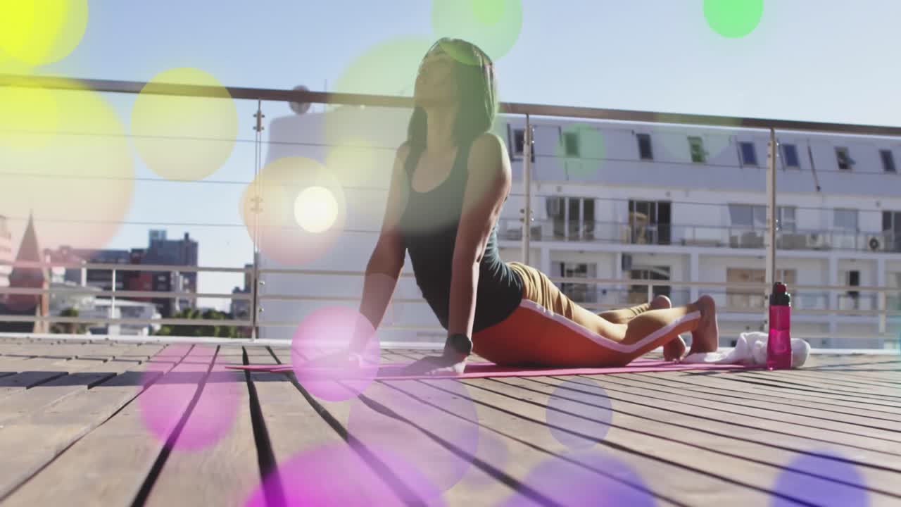 animación de luces brillantes sobre una mujer biracial practicando yoga