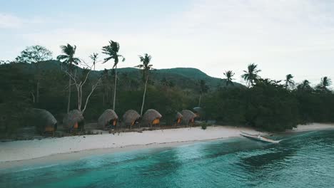 Volando-Hacia-Un-Par-De-Bungalows-En-Una-Playa