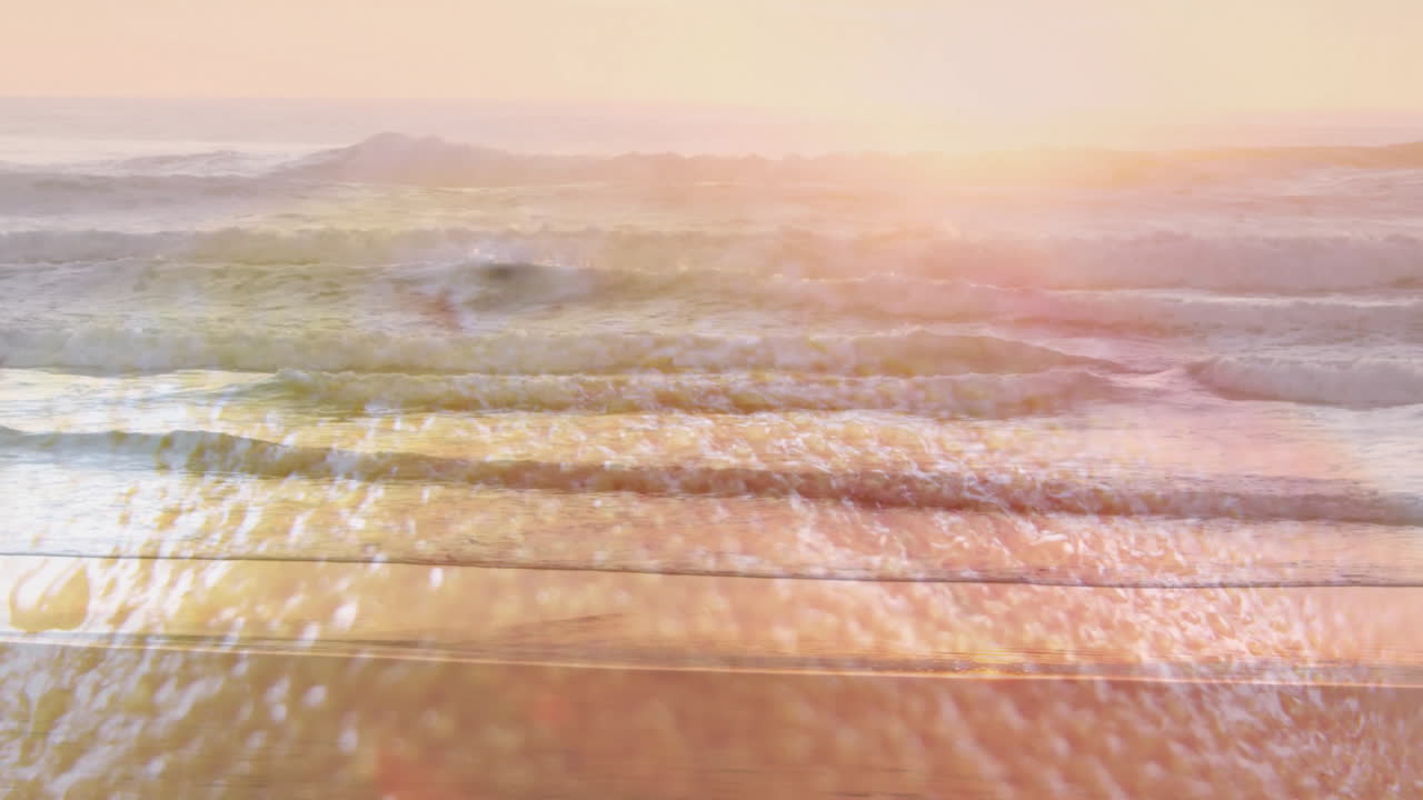 Animation of waves gently crashing on sandy beach under warm, golden sunlight