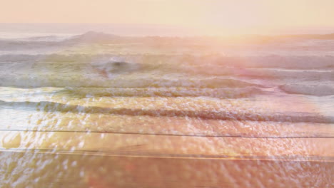 animation of waves gently crashing on sandy beach under warm, golden sunlight