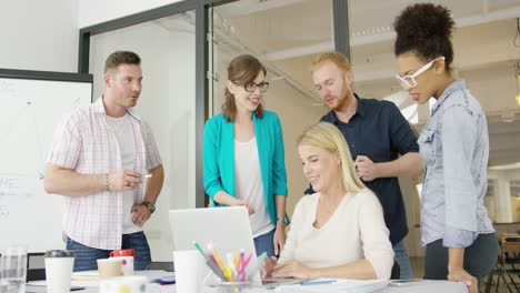 coworkers with laptop in office