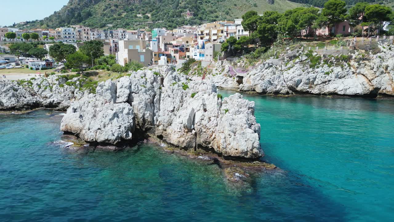 Aerial drone footage of Sant’Elia cove in Sicily: turquoise sea, rocky coastline, hidden beach, and Mediterranean charm. Perfect for travel, nature, and summer holiday projects