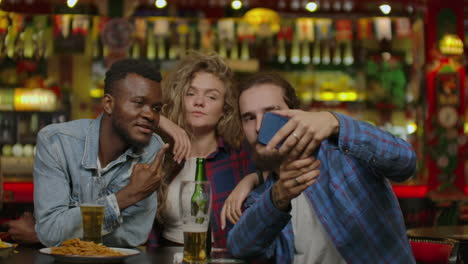 group of happy multiracial friends making a toast with beer at bar or pub.