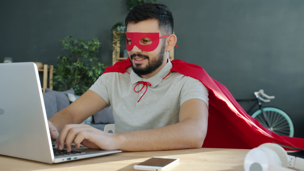 Man in Superhero Costume Working on Laptop