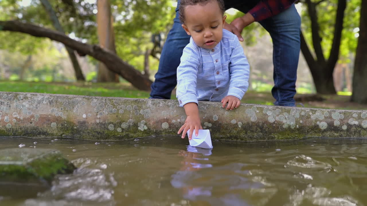 아버지는 종이 선박을 떠나고, 아들은 그것을 잡습니다.