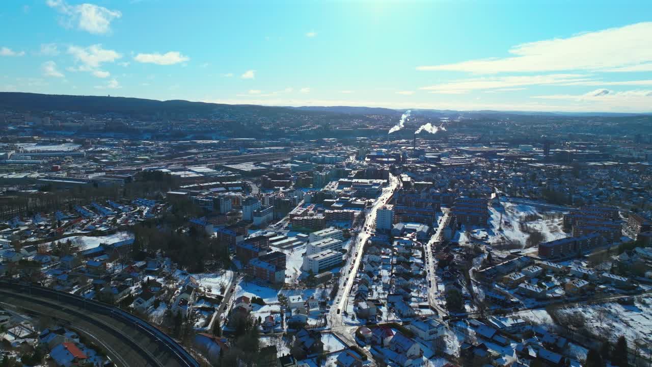 Sunny blue sky daytime Oslo power plant cooling towers Norway Norge aerial drone Norwegian winter Bjerke Travbane Tonsenhagen apartment buildings Nordmarka snowy cars highway static shot