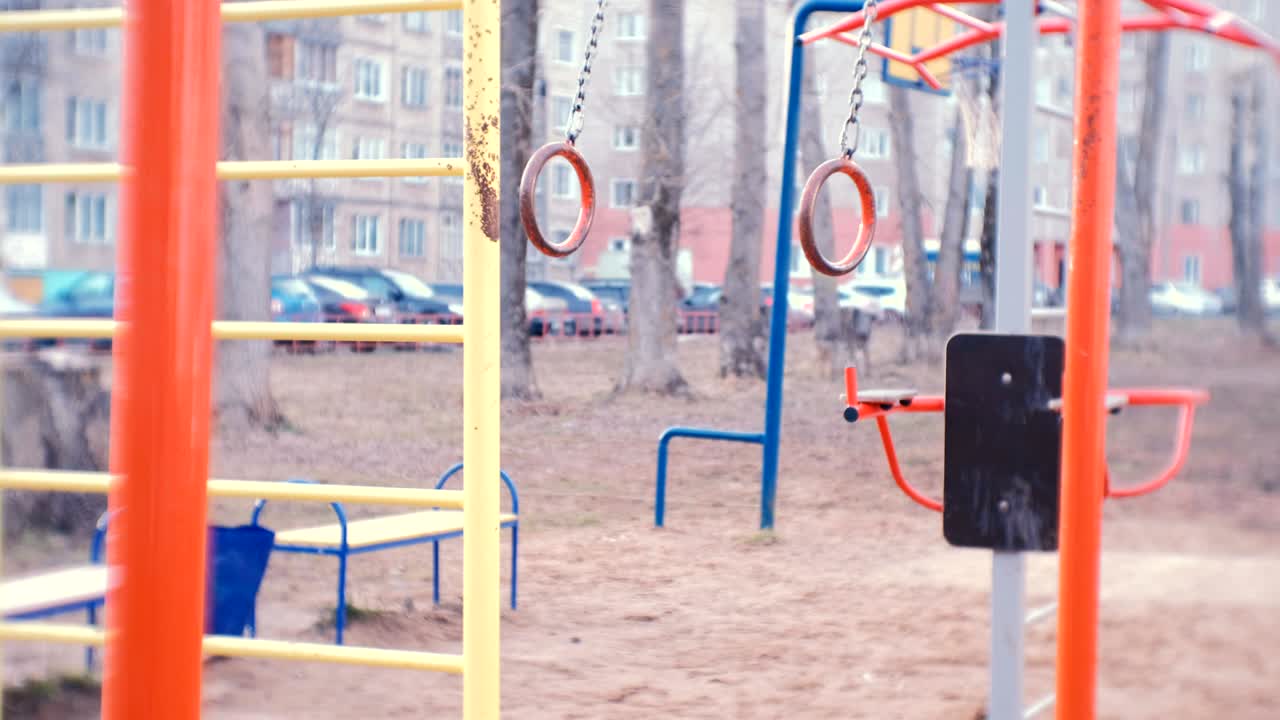los anillos de gimnasia se balancean en el patio de la casa de la ciudad en el parque infantil.