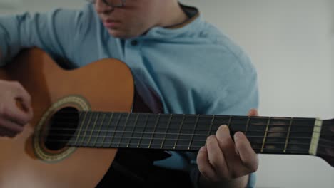 hombre caucásico adulto con síndrome de down tocando la guitarra