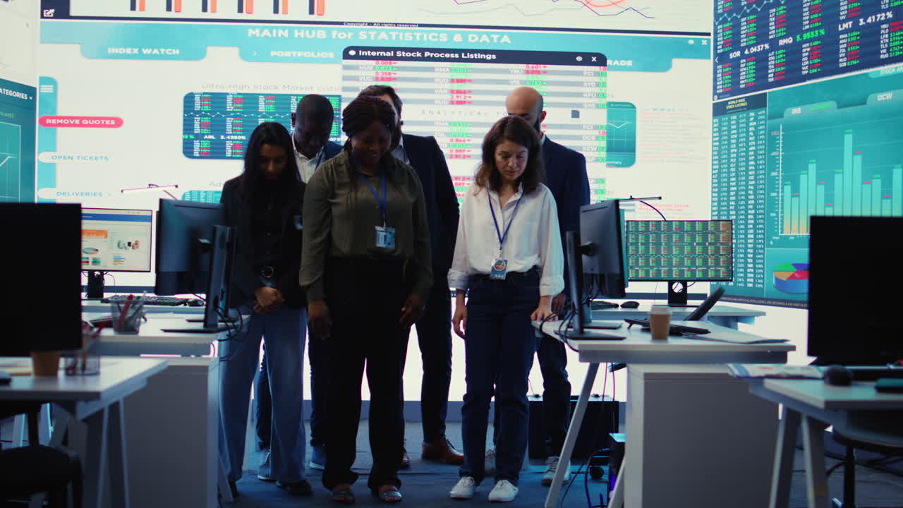 Diverse group of business professionals posing together in monitoring room