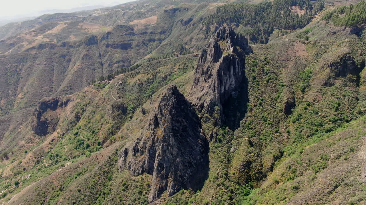vista aérea en órbita sobre las fantásticas formaciones rocosas de roque chico y roque grande en la reserva natural, en la isla de gran canaria en un día soleado