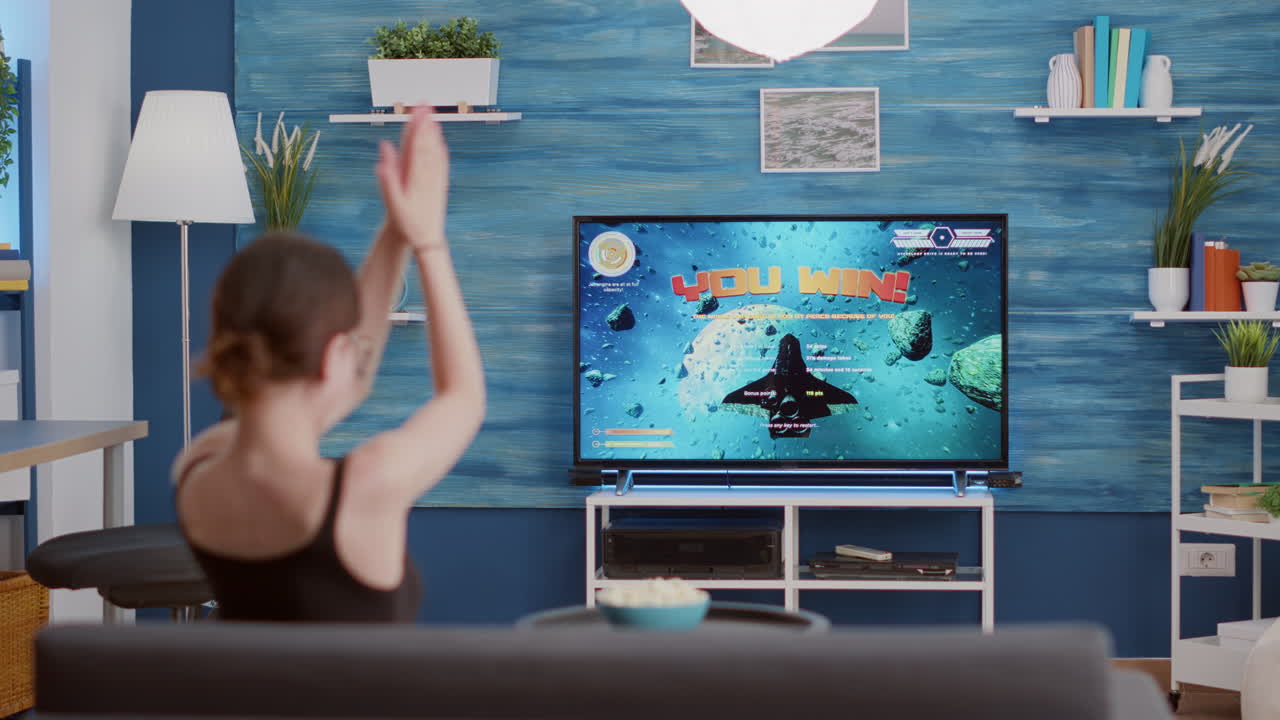 Gamer girl holding controller celebrating victory in online first person shooter game