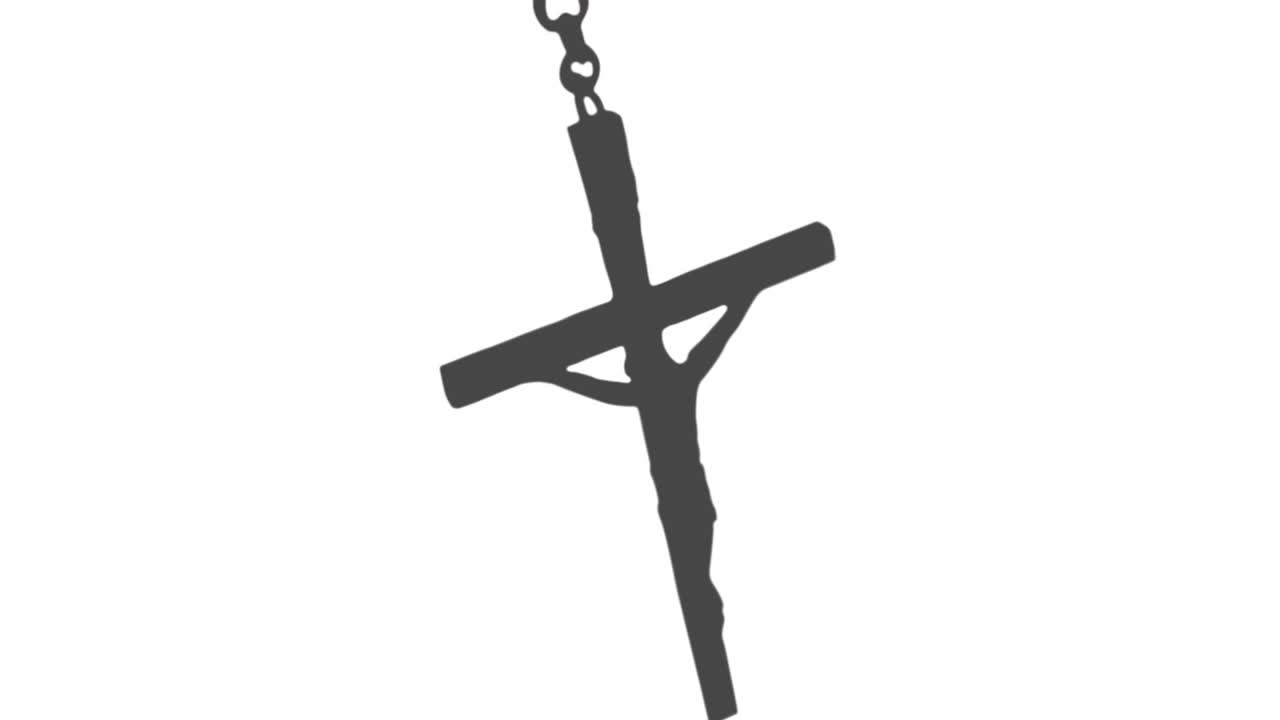 Crucifix pendant rotating and bobbing from gentle breeze, chain shifting, sun rays glinting