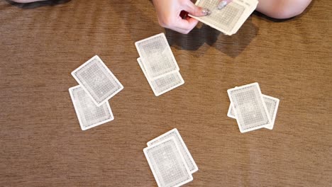 hands shuffling and dealing playing cards on table