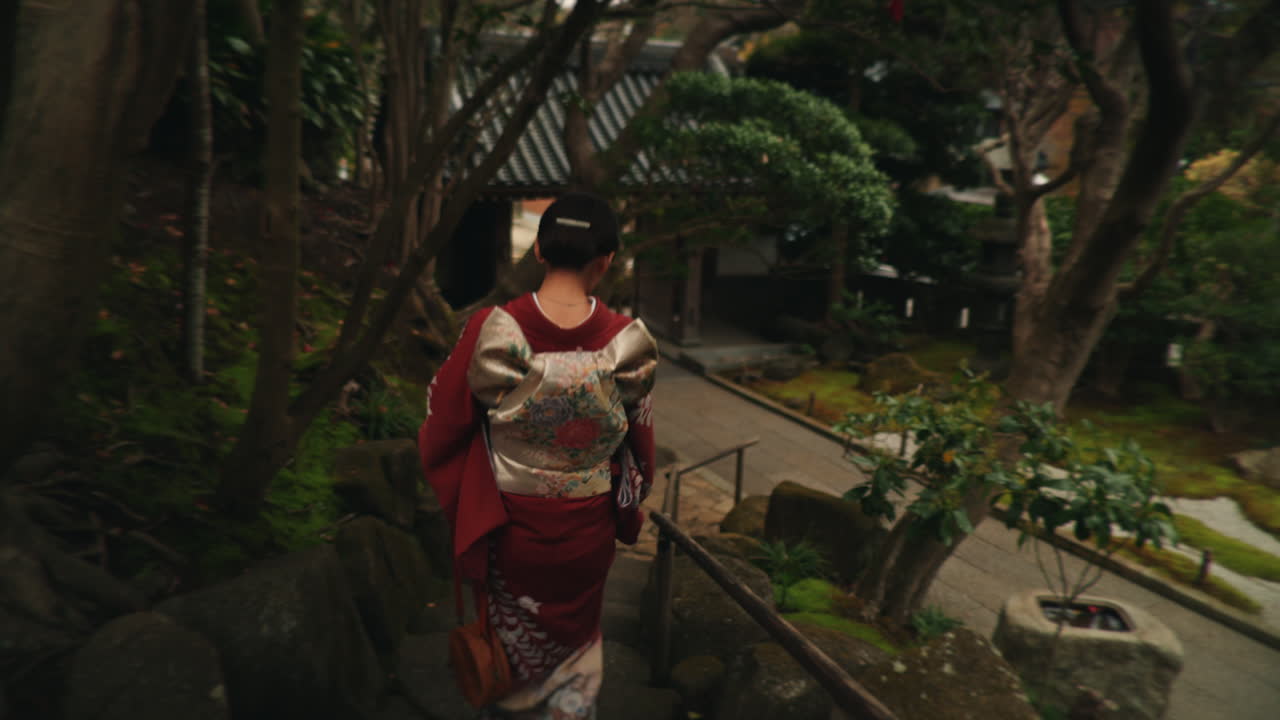 Woman in Kimono Walking Down Stone Steps in a Japanese Garden