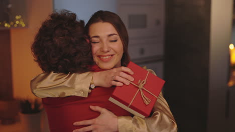 happy woman embracing partner while receiving a gift