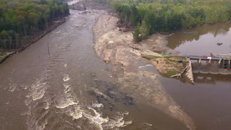 Toma-De-Drones-De-Una-Presa-Y-Un-Río-Que-Fluye-Junto-Al-Lago-Wixom-Durante-La-Inundación