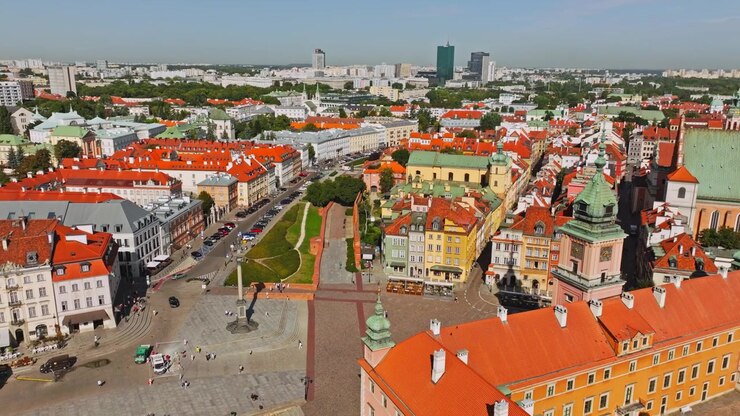 Ripresa aerea cinematografica su Piazza del Castello (Plac Zamkowy) a Varsavia, Polonia, in pieno giorno soleggiato.
