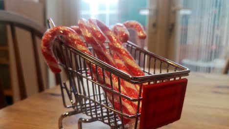 pequeño carrito de compras lleno de bastones de caramelo de navidad concepto de entrega a domicilio idea de cocina retirar