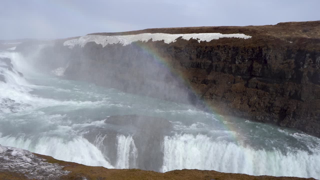 majestuosa cascada gullfoss en islandia con un arco iris vibrante, temporada de invierno