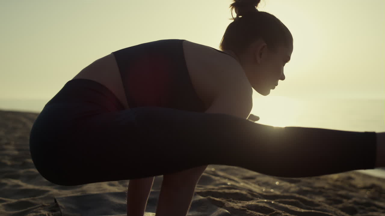 mujer atlética con los brazos de pie extendiendo las piernas a los lados practicando yoga de cerca.