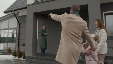 real estate agent showing house to family