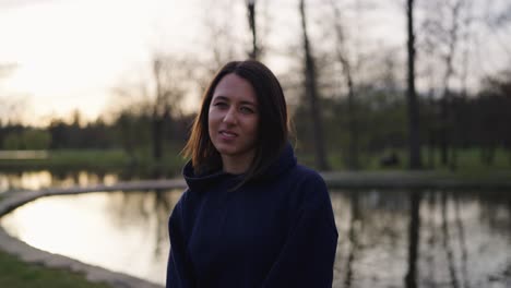 happy female stand near bright evening pond with tree reflection, czechia