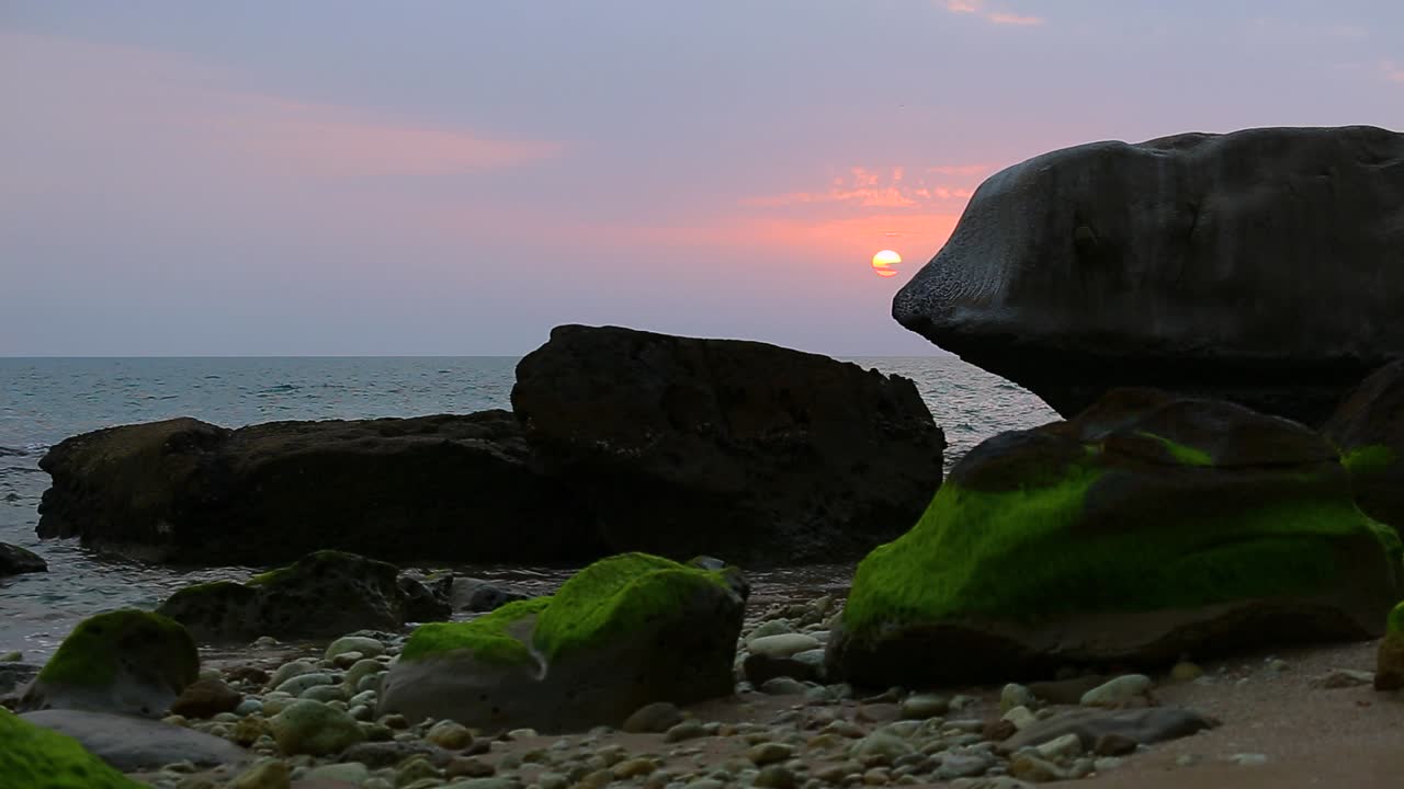 hermoso atardecer horizonte naranja en el fondo cielo nublado en la noche ola del mar y color verde algas en la playa de piedra roca maravilloso paisaje de pintoresca aventura marina deporte marítimo viaje a los emiratos árabes unidos irán