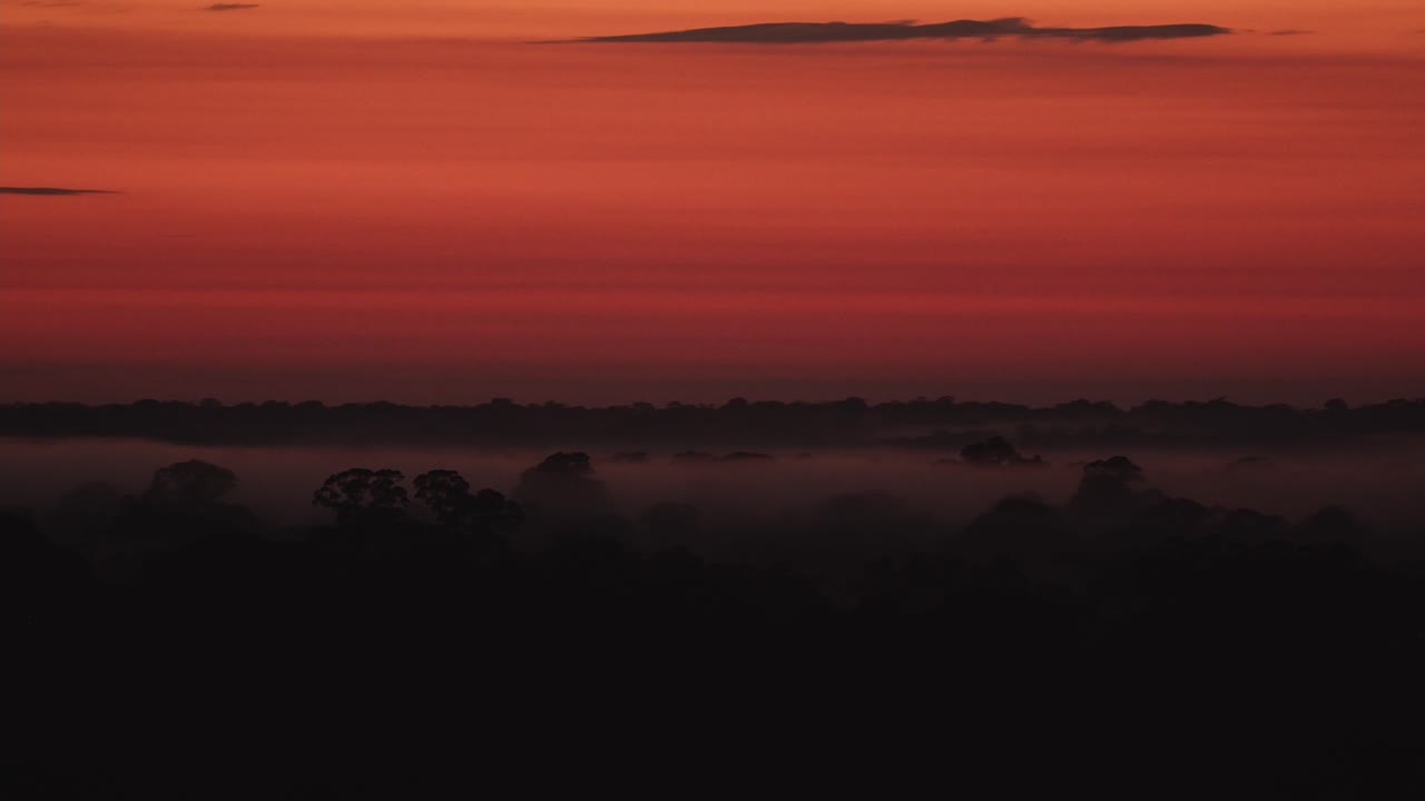 En levende oransje solnedgang avslutter dagen i Tambopata nasjonalreservat