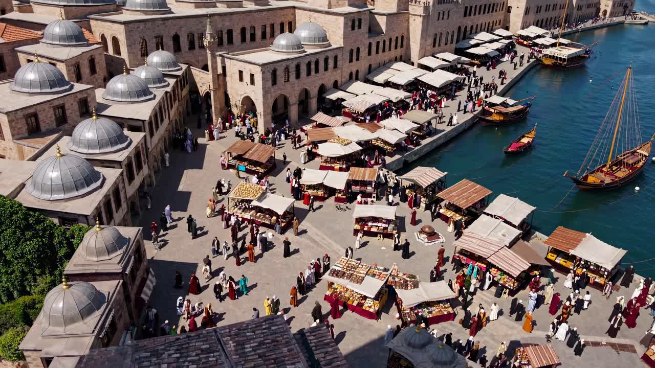 Video aereo cattura un vivace mercato sul lungomare con architettura tradizionale e bancarelle vivaci