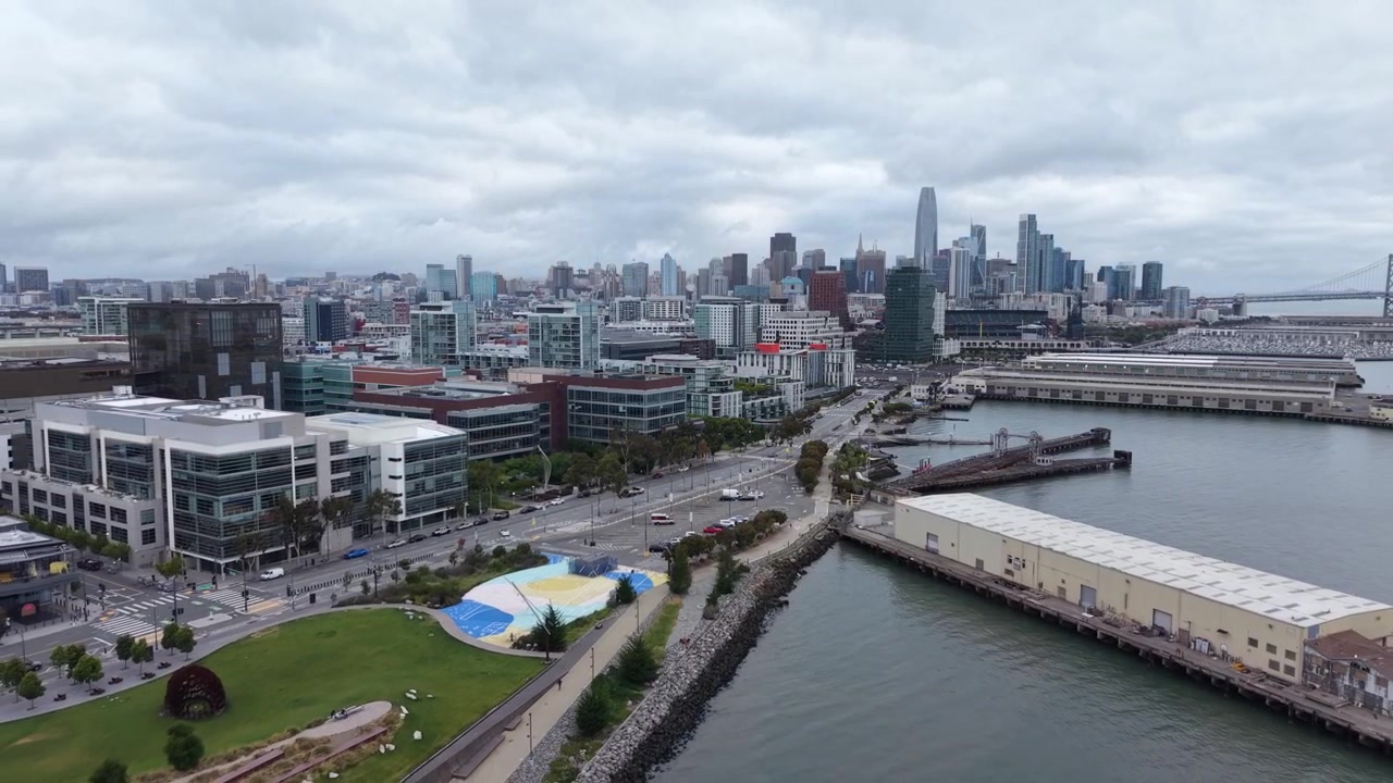 Vedute aeree di Mission Bay mostrano la sua costa, gli sviluppi moderni, gli spazi verdi e il lungomare vicino. Il volo cattura l'atmosfera energica del quartiere e il paesaggio urbano in evoluzione