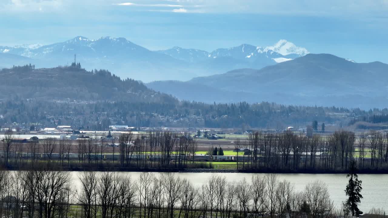 Mission, British Columbia, Canada - A Peaceful View of the Fraser Valley With the Mountains Rising in the Distance - Pan Up Shot