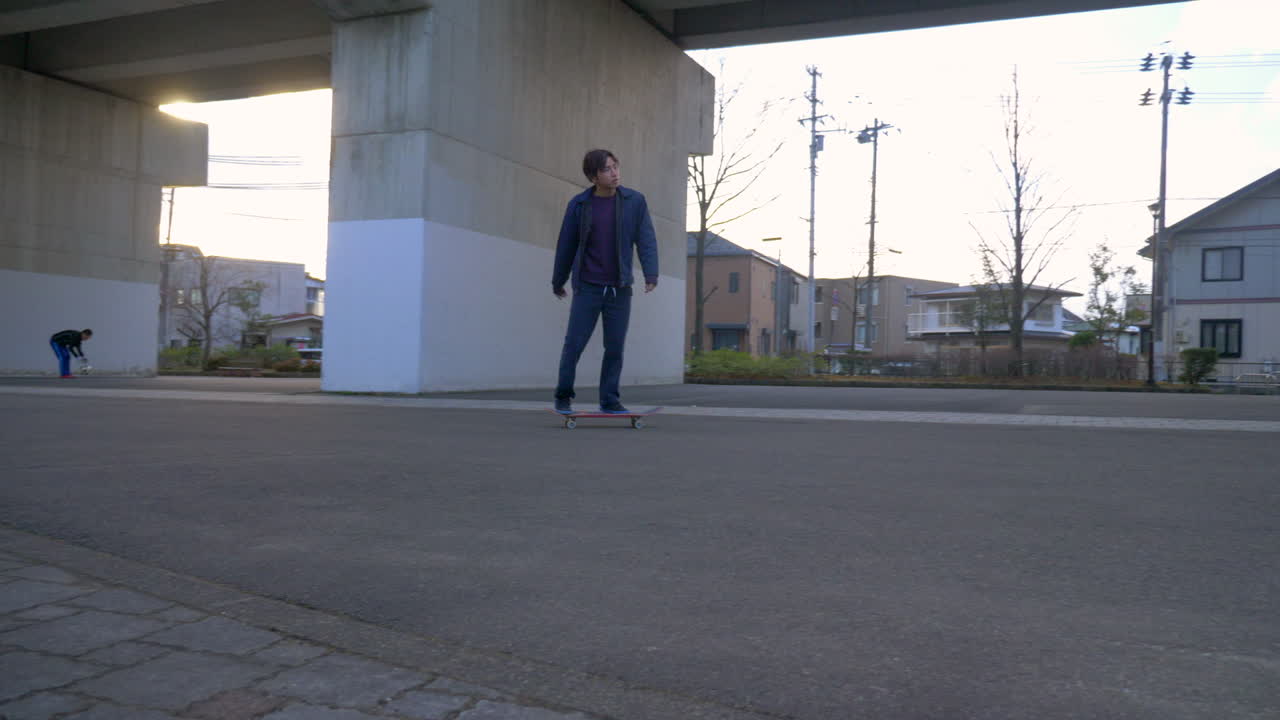 Young Japanese man riding his skateboard in urban Japan.