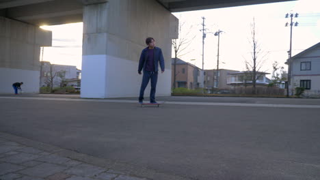 young japanese man riding his skateboard in urban japan.