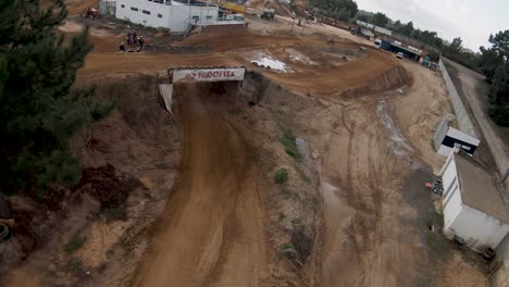 aerial fpv rounds tree to reveal motocross riders talking and relaxing