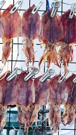 squid drying on racks at a street food stall